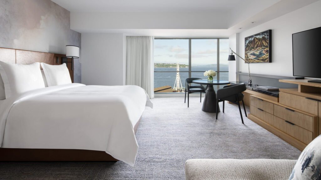 Ocean-view luxury suite at Four Seasons Hotel Seattle with plush bedding